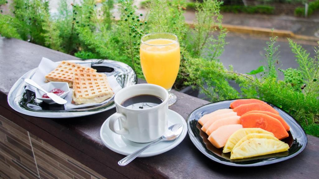 Desayuno con café, jugo, frutas y waffles en Hotel BLH
